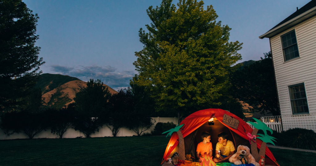 kids camping in a tent in backyard 