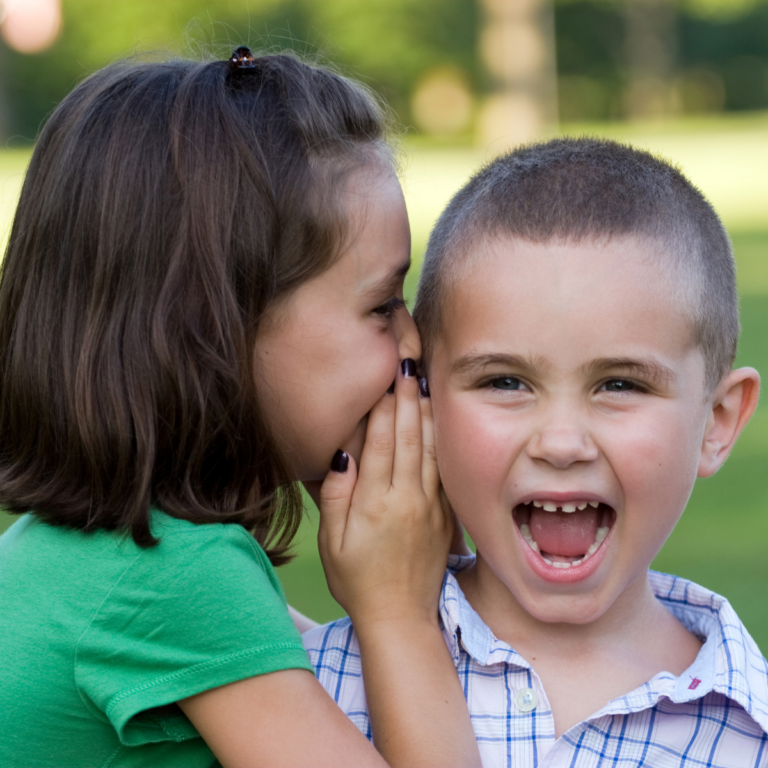 two children telling secrets